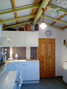 a kitchen with white cabinets and a wooden door at Myrovolos in Armenistis