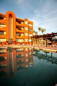 a hotel with a swimming pool in front of a building at Sunrock Hotel & Suites in Cabo San Lucas