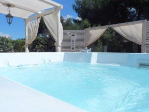 a large swimming pool with an umbrella at B&B Santa Venardia in Gallipoli