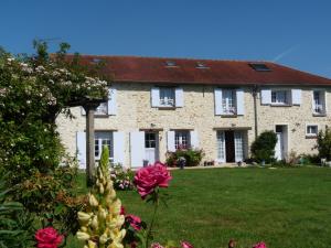 a large brick house with flowers in front of it at L'Etable d'Orgerus in Orgerus
