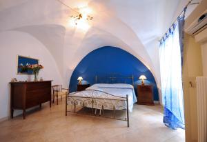 ガリポリにあるPalazzo Rocci Roomsの青と白の天井のベッドルーム1室、ベッド1台が備わります。