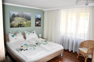 a bedroom with a large bed with white sheets at Gästehaus Wachau in Leiben