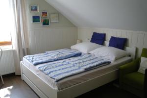 - un lit avec des oreillers bleus et blancs dans une chambre dans l'établissement Nóra Apartman, à Gyula