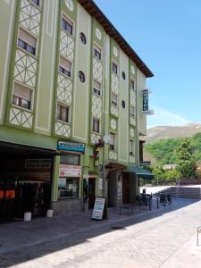 a large green building with tables in front of it at Pension Monteverde in Cangas de Onís