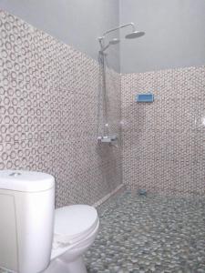 a bathroom with a toilet and a shower at Sawe Homestay in Kuta Lombok