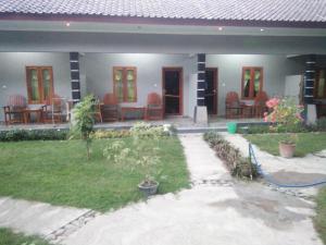 a house with a patio with chairs and a yard at Sawe Homestay in Kuta Lombok