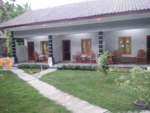 a home with a patio with chairs and a yard at Sawe Homestay in Kuta Lombok