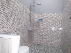 a bathroom with a shower and a toilet in it at Sawe Homestay in Kuta Lombok
