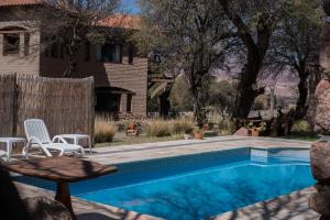 
a pool with a chair and a lawn chair in it at La Casa De La Bodega - Wine Boutique Hotel in Cafayate
