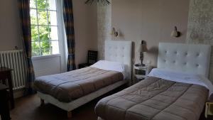 a bedroom with two beds and a window at Hôtel du Puy d'Alon in Souillac +72 photos