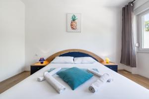 a bedroom with a white bed with two pillows at Sobe Mateša in Vodice