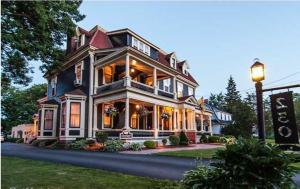 a large house with a porch on a street at Carriage House Inn in Fredericton