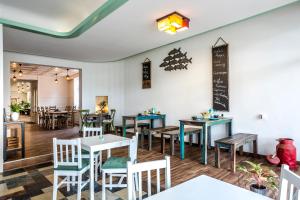 a restaurant with tables and chairs and a chalkboard on the wall at Mooi Hotel Garni in Friedrichstadt