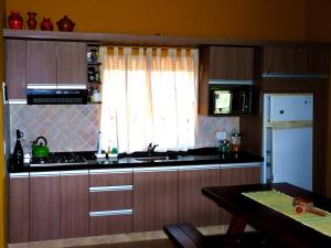 a kitchen with wooden cabinets and a sink and a window at Terrazas al Champaqui in Villa Yacanto