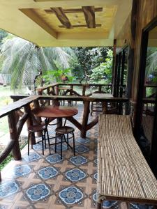a porch with a table and chairs on a tiled floor at Dabdab Tourist Inn in Sabang