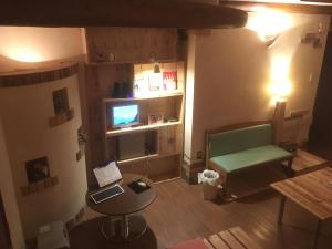 a living room with a green couch and a television at ILA Hakushu Guesthouse in Hokuto