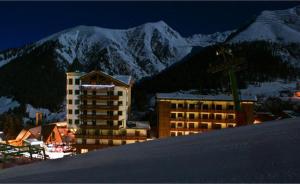 a building in front of a snow covered mountain at Appartamenti Fronte Piste - Appartamentiflarida Foppolo in Foppolo