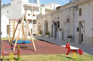 een speeltuin met een glijbaan en een schommel bij B&B Aia Vecchia in Cisternino