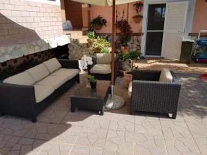 a patio with a couch and chairs and an umbrella at Carla's rooms in Rome