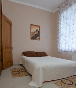 a bedroom with a large bed and a window at Karavella in Mykolaiv