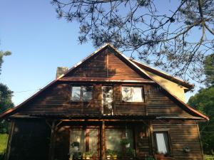 ein altes Holzhaus mit Fenstern in der Unterkunft Bieszczadzki Zakątek :-) in Skorodne