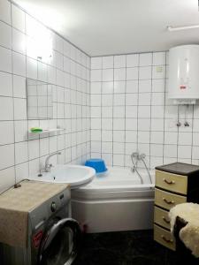 a bathroom with a tub and a sink and a bath tub at Аркадия Флэт in Odesa
