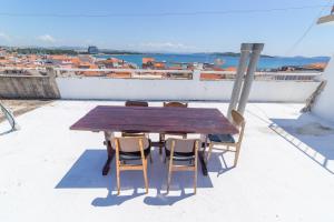 een houten tafel en stoelen op een dak bij Sobe Mateša in Vodice