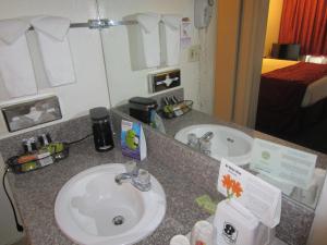 a bathroom counter with a sink and a mirror at Kings Inn Anaheim at The Park & Convention Center in Anaheim