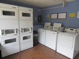 a laundry room with white washers and dryers at Kings Inn Anaheim at The Park & Convention Center in Anaheim