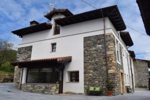 a white building with a black roof at L'Arbolea de Rodiles in Villaviciosa