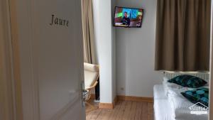 um quarto com uma porta com uma televisão na parede em B&B Stoega em Bruges