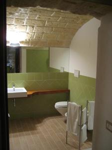 een badkamer met een wastafel, een toilet en een spiegel bij Antico Molino in Trani