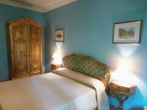 a bedroom with a bed and two night stands with lamps at Cortebella B&B Rimini in Vergiano