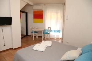 een slaapkamer met een bed en een tafel en stoelen bij B&B Il Tramonto in Castelsardo