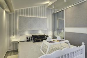 een slaapkamer met een wit bed en een tafel bij Apartments Zanetti 2 in Pula