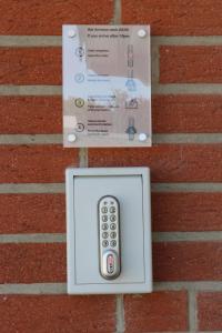 a remote control in a box on a brick wall at Hotel Baldus in Delmenhorst