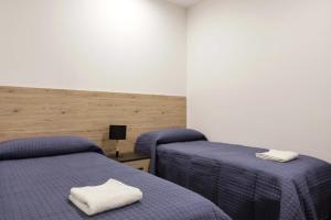2 łóżka w pokoju z fioletową pościelą w obiekcie Beach Home w mieście Agnone Bagni