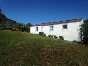 a white house on top of a grassy hill at Casa do Alto in Santana +20 photos