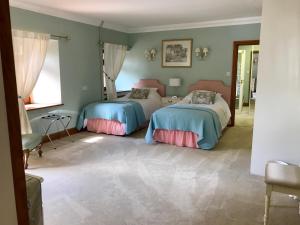 a bedroom with two beds and a mirror at Seawell in Towcester