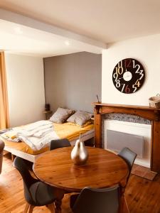 una camera con due letti, un tavolo e un orologio di Comme à la maison a Boulogne-sur-Mer