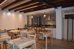a restaurant with tables and chairs and a kitchen at L'Arbolea de Rodiles in Villaviciosa