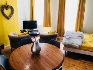 un soggiorno con tavolo, sedie e un letto di Comme à la maison a Boulogne-sur-Mer
