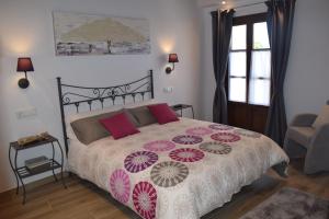 1 dormitorio con 1 cama grande con almohadas rojas y rosas en L'Arbolea de Rodiles en Villaviciosa