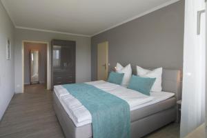 a bedroom with a large white bed with blue pillows at Fi-Suiten in Waldeck