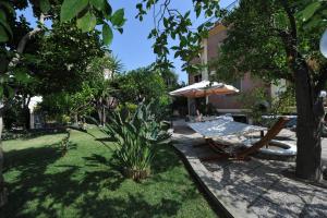 un patio con sombrilla, silla y mesa en Estate4Home - Orange Dreams en Sant'Agnello