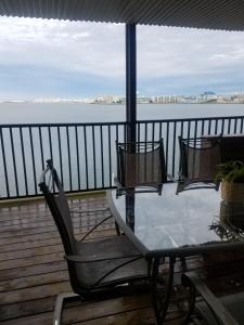 een tafel en stoelen op een terras met uitzicht op het water bij Bahama Princess Condos in Ocean City