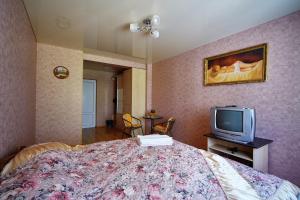 Un dormitorio con una cama y un televisor. en Domashniy, en Kamianets-Podilskyi