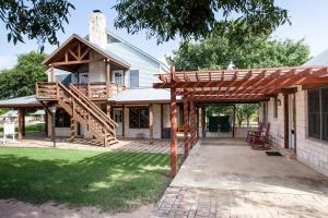 a home with a wooden pergola and a house at Gruene Cottages in New Braunfels