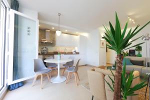 salon i kuchnia ze stołem i krzesłami w obiekcie La Tierra Sur apartment Malaga Center w Maladze