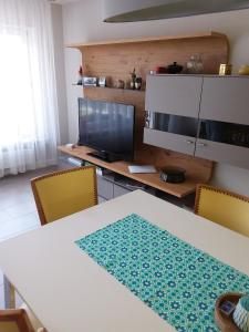 uma sala de jantar com uma mesa e cadeiras e uma televisão em Konstanz em Constança